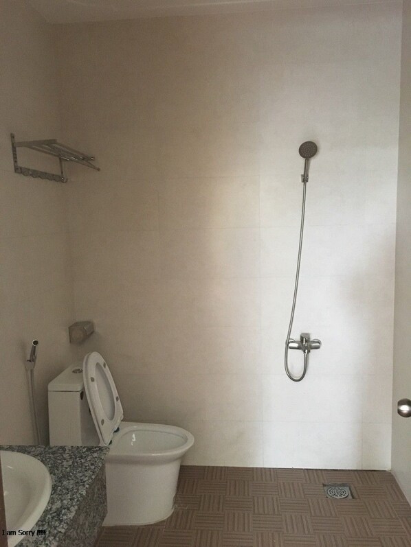 Un baño con inodoro, lavamanos y ducha.