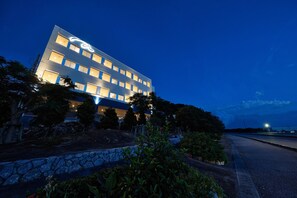 Un moderno edificio de hotel con varios pisos y ventanas iluminadas.