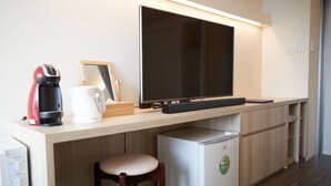 Una kitchenette equipada con microondas, cafetera y refrigerador pequeño.