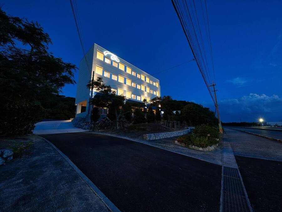 A modern hotel with a rectangular facade, multiple windows, and a well-lit entrance.
