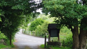 A rural road with a wooden signpost and a metal fence. - Rhymney House hotel (Tredegar)