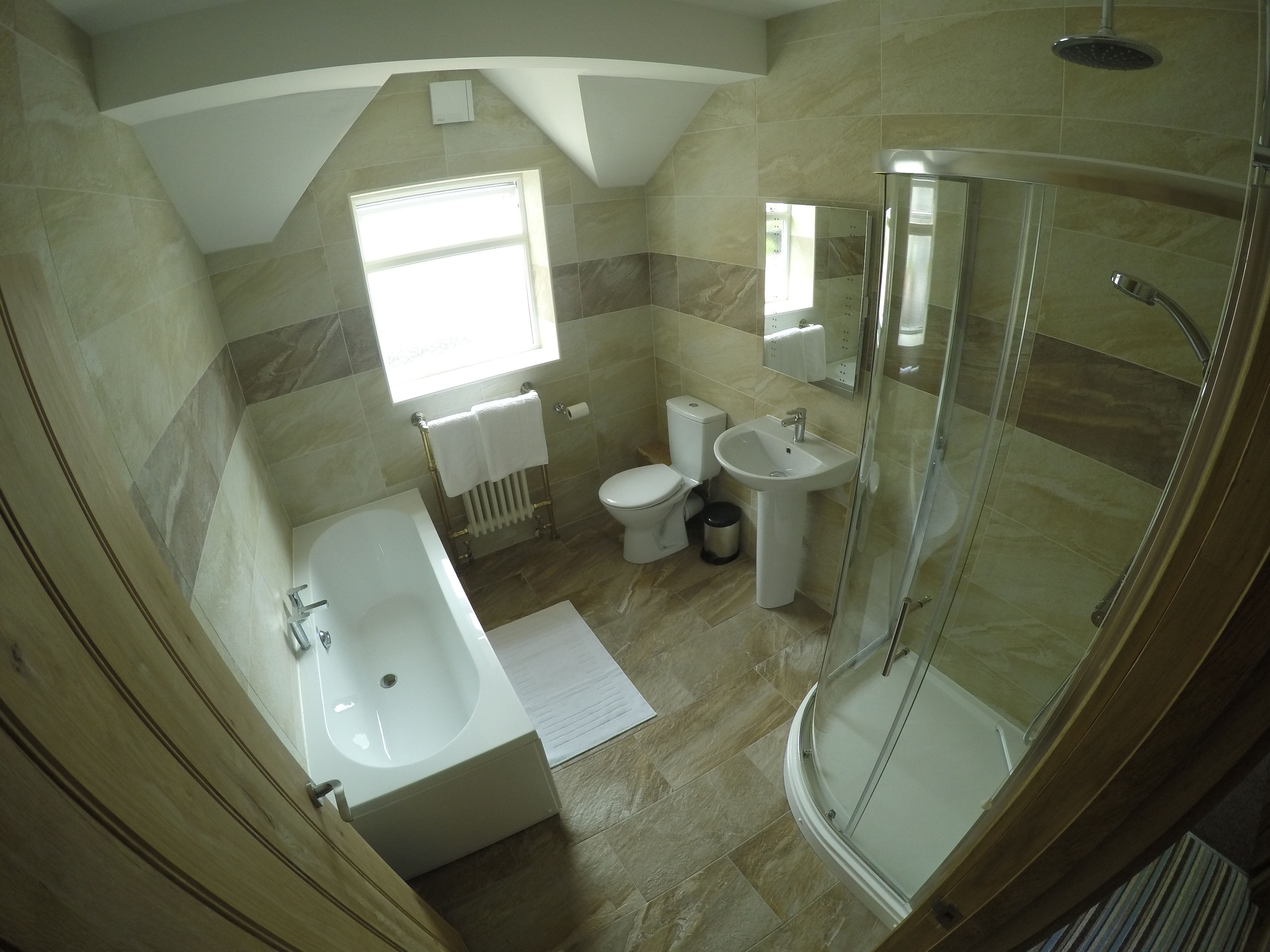 Un baño moderno con bañera, inodoro, lavabo y cabina de ducha de vidrio.