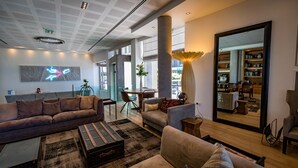 A spacious living area with a modern design, featuring a large sofa, a coffee table, and a bookshelf.