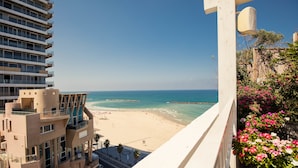 A high-rise building with balconies overlooking a beach.