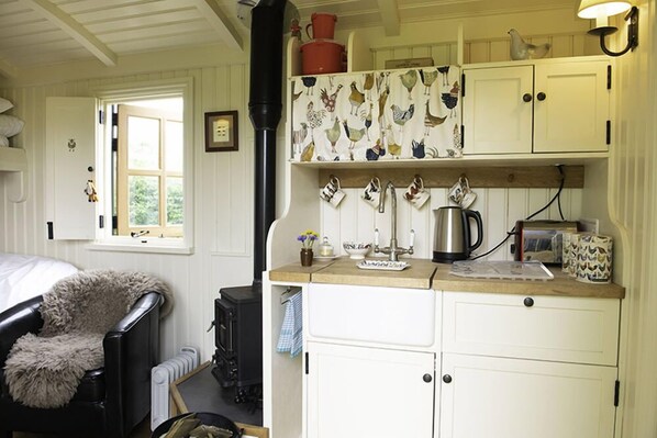 A cozy kitchen with white cabinets, a black stove, and a window with a view.