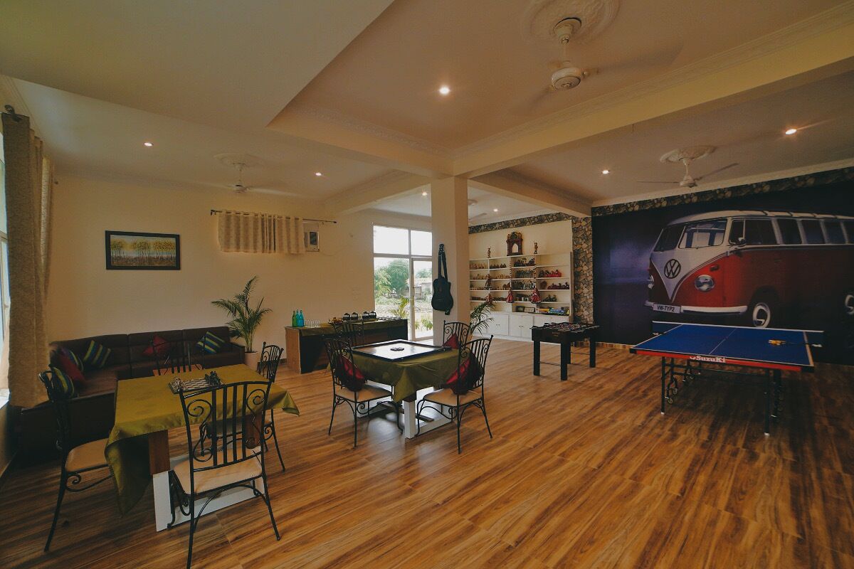 A spacious living area with a ping pong table, a sofa, and a dining table.