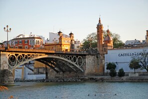 A historic stone bridge with ornate metalwork and a river below. - Triana Luxury Home (Seville)