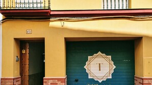 Un edificio con una puerta de garaje verde marcada con una 'T' grande y el nombre 'TRIANA'.