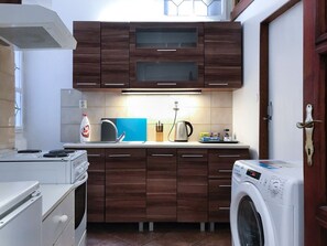 Enjoy cooking and laundry facilities in this well-equipped kitchen with oven, microwave, and washing machine.