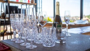 Une table avec différents types de verres à vin et une bouteille de champagne.