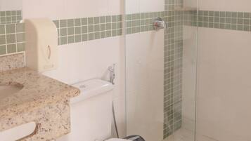 A bathroom with a toilet, sink, and shower area.