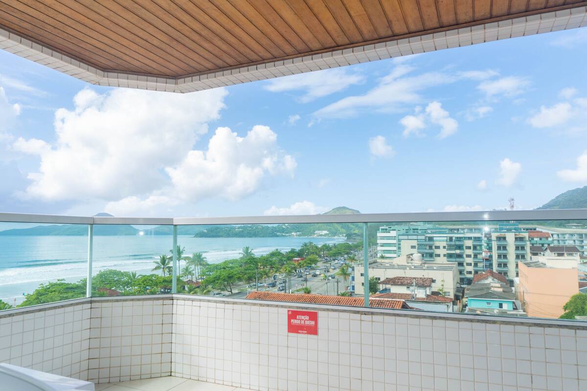 A balcony with a view of the ocean and cityscape.