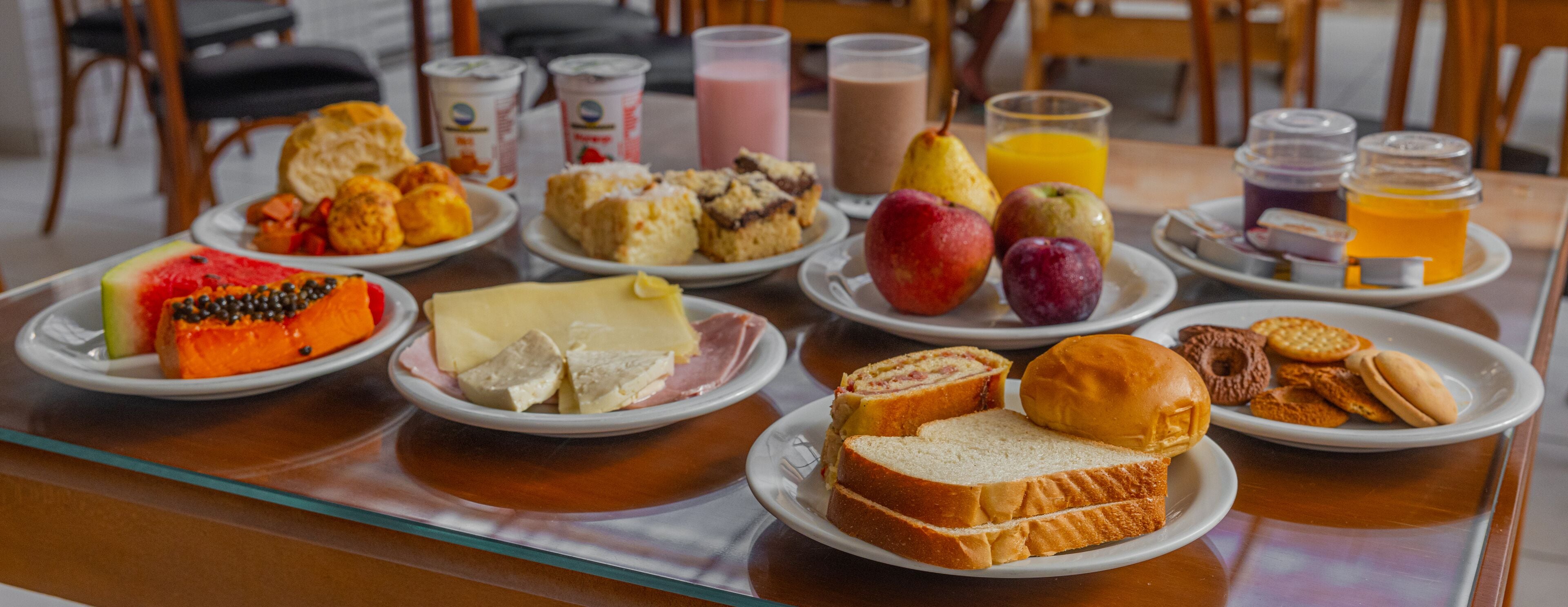 Um buffet de café da manhã com diversos alimentos e bebidas.