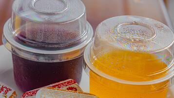 A tray with two containers of food, one with a purple substance and the other with an orange liquid, and several small containers of yogurt.