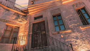 A historic building with multiple windows and balconies, featuring stone walls and wrought iron railings. - Atillas Cave Hotel (Nevsehir)