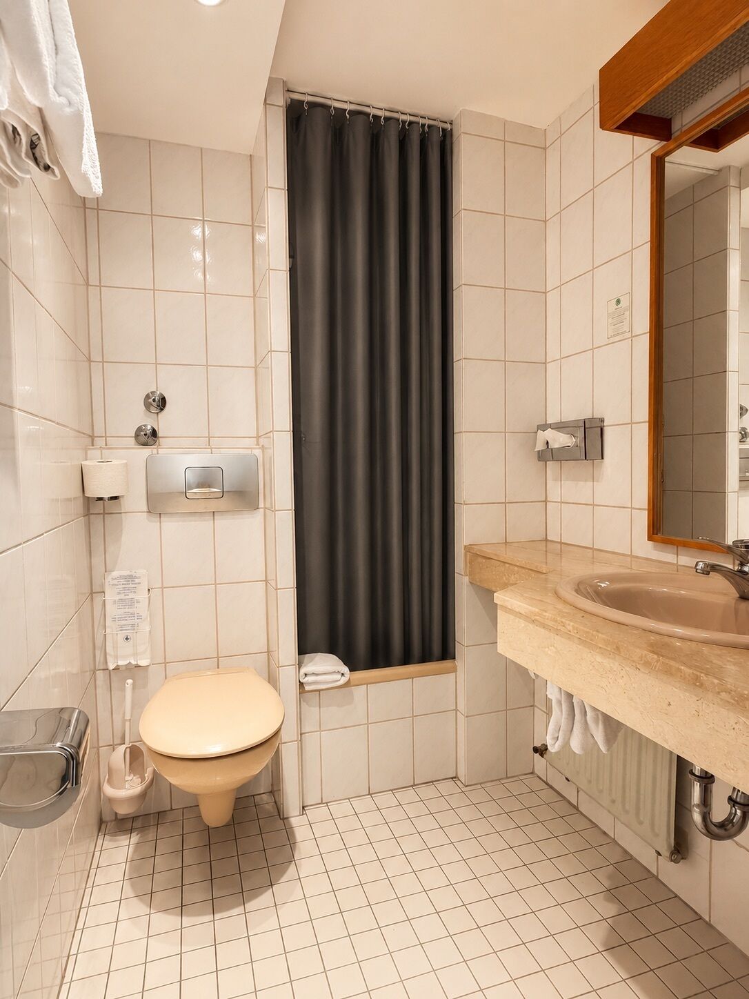 A bathroom with a toilet, sink, and shower curtain.