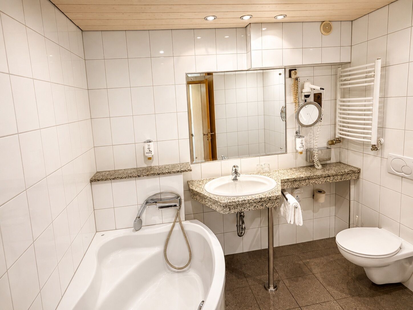 Un baño moderno con bañera, lavamanos e inodoro.