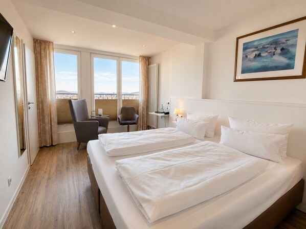 A hotel room with two beds, a chair, a desk with a lamp, and a painting on the wall. - Burghotel Volmarstein (Wetter)