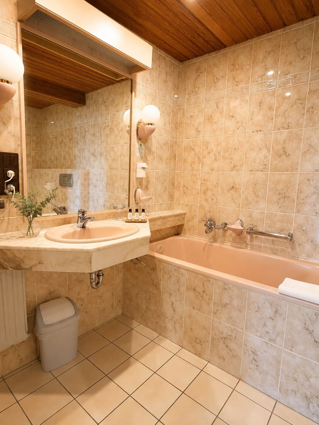 A bathroom with a sink, mirror, vanity, and bathtub.