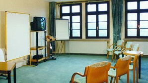 A conference room with a whiteboard, a television, and several chairs. - Burghotel Volmarstein (Wetter)