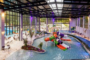 An indoor swimming pool with slides and lounge areas. - Vale Suiço Resort (Itapeva)