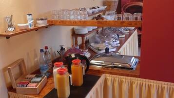 Un buffet de petit-déjeuner proposant une variété d'aliments, de couverts et de verrerie.