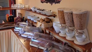 A buffet setup with various food items and utensils. - Hotel Prox (Arnstadt)