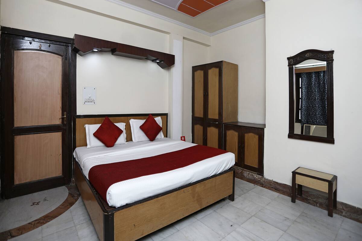 A neatly arranged bedroom with a bed, wardrobe, and a small table.