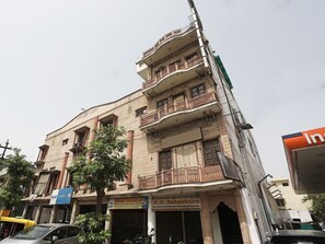 A multi-story building with commercial spaces on the ground floor, including a car dealership and a travel agency. - OYO 12671 Hotel Prithvi Palace (Ghaziabad)