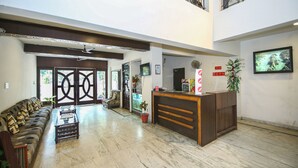 A spacious lobby with a reception desk, seating area, and a staircase leading to an upper level. - Hotel Datt Residency (Jabalpur)
