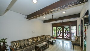 A spacious living area with a sofa set, a coffee table, and a bookshelf. - Hotel Datt Residency (Jabalpur)