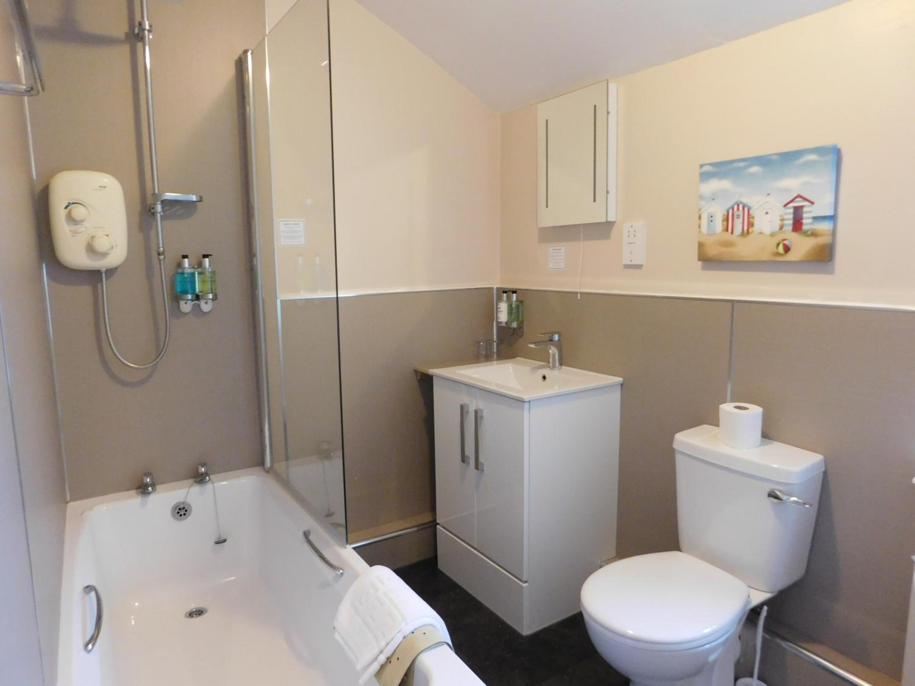 A modern bathroom with a bathtub, toilet, and sink.