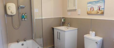 A modern bathroom with a bathtub, toilet, and sink.
