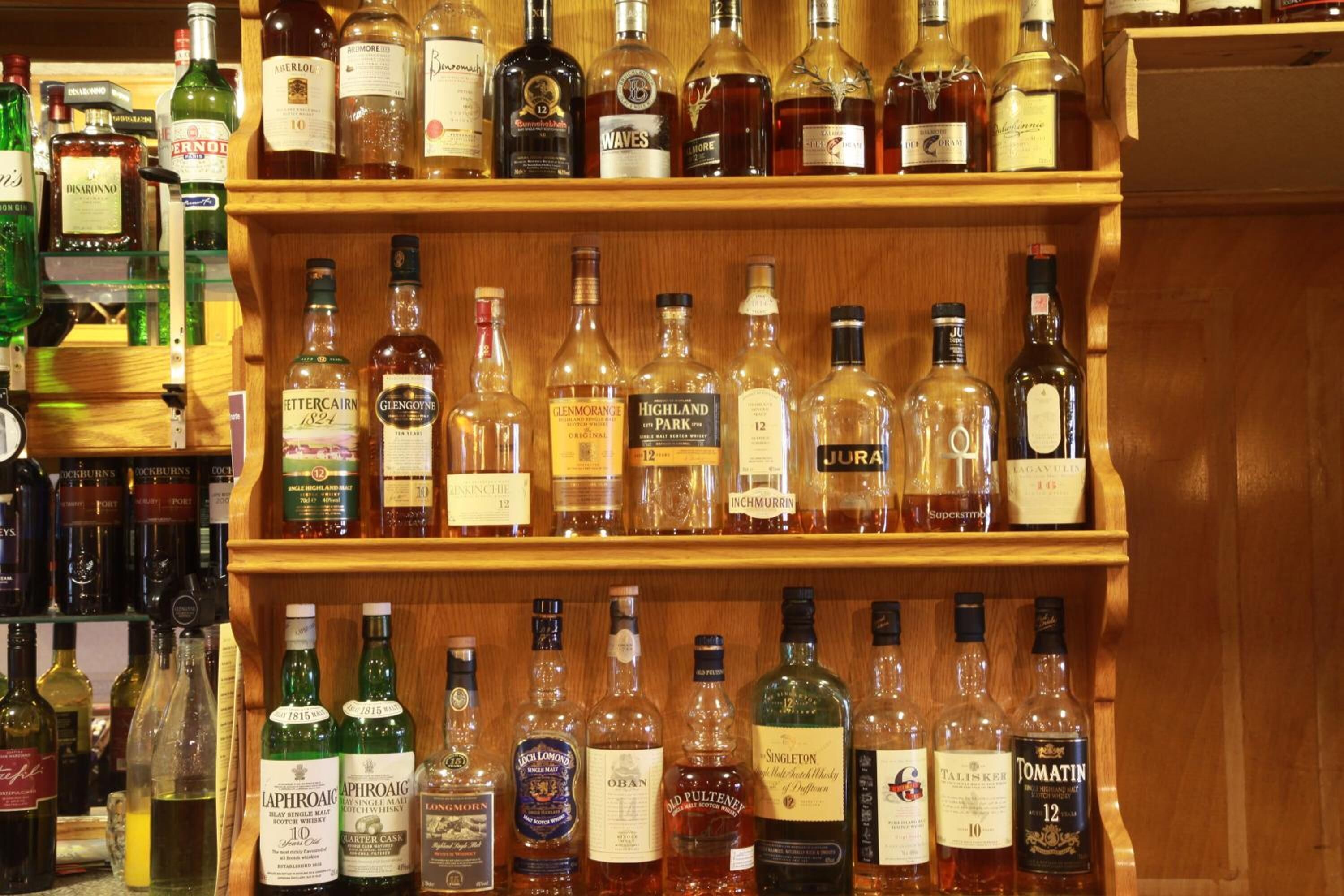 Een slijterij met schappen vol met verschillende soorten alcohol.