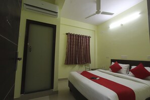 A hotel room with a bed, a ceiling fan, an air conditioning unit, and a door. - OYO 15776 V R Residency (Bengaluru)