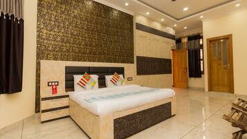 A hotel room with a bed, a wardrobe, a ceiling fan, and a bathroom door.