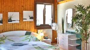 A bedroom with a wooden ceiling, a bed, a dresser, a mirror, and a potted plant. - Hôtel du Port (Estavayer-le-Lac)