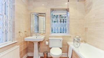 Un baño con inodoro, lavabo y bañera.