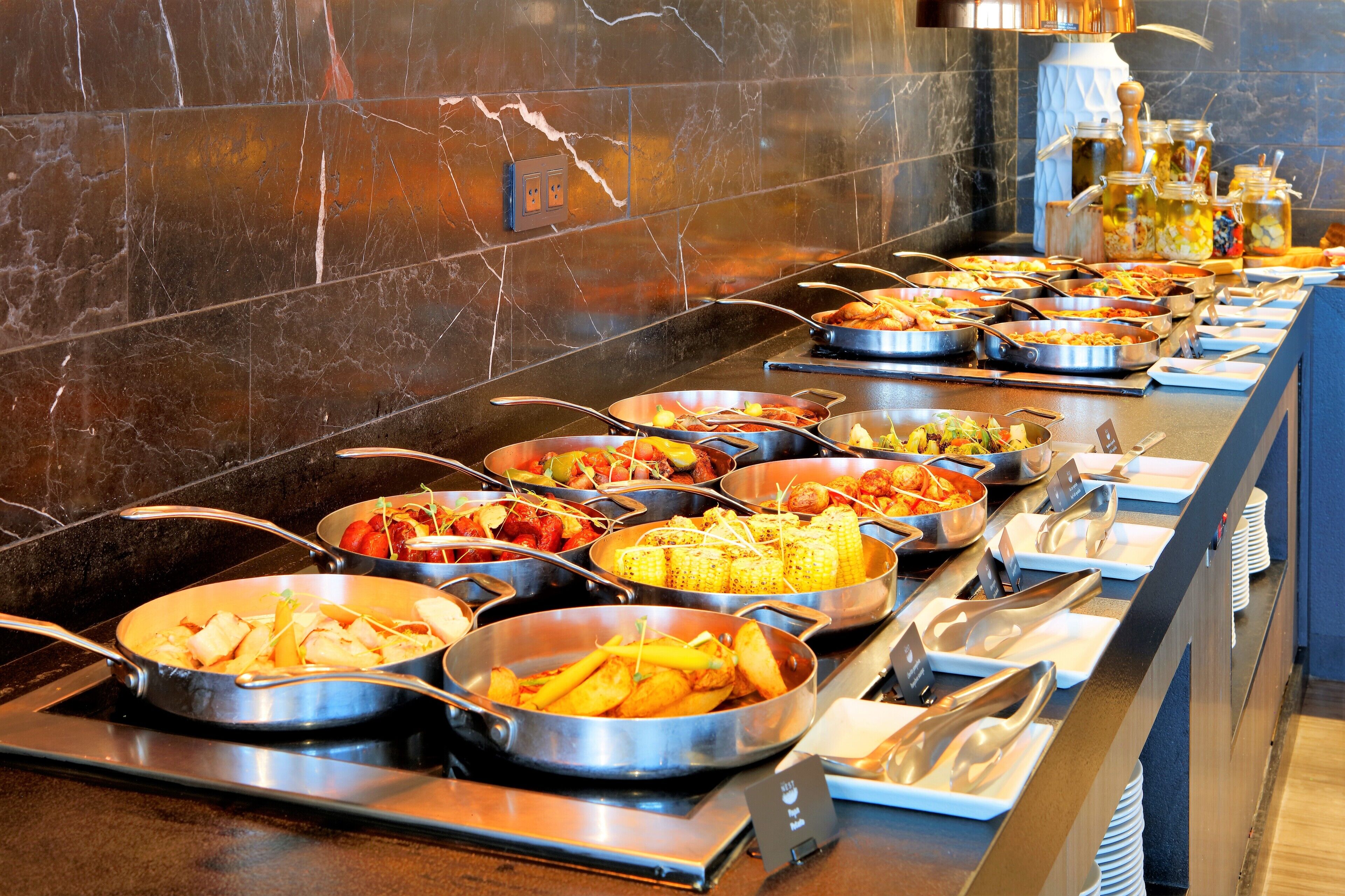 A buffet with various dishes and utensils.