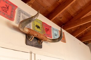 A wooden ceiling with a decorative horn mounted on a wall. - Antelope Lodge (Alpine)