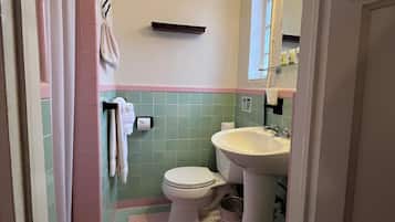 A bathroom with a toilet, sink, and a towel rack.