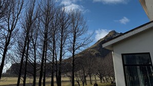 A modern building with a clear sky and mountains in the background.