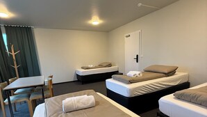 A hotel room with two beds, a desk, and a chair.