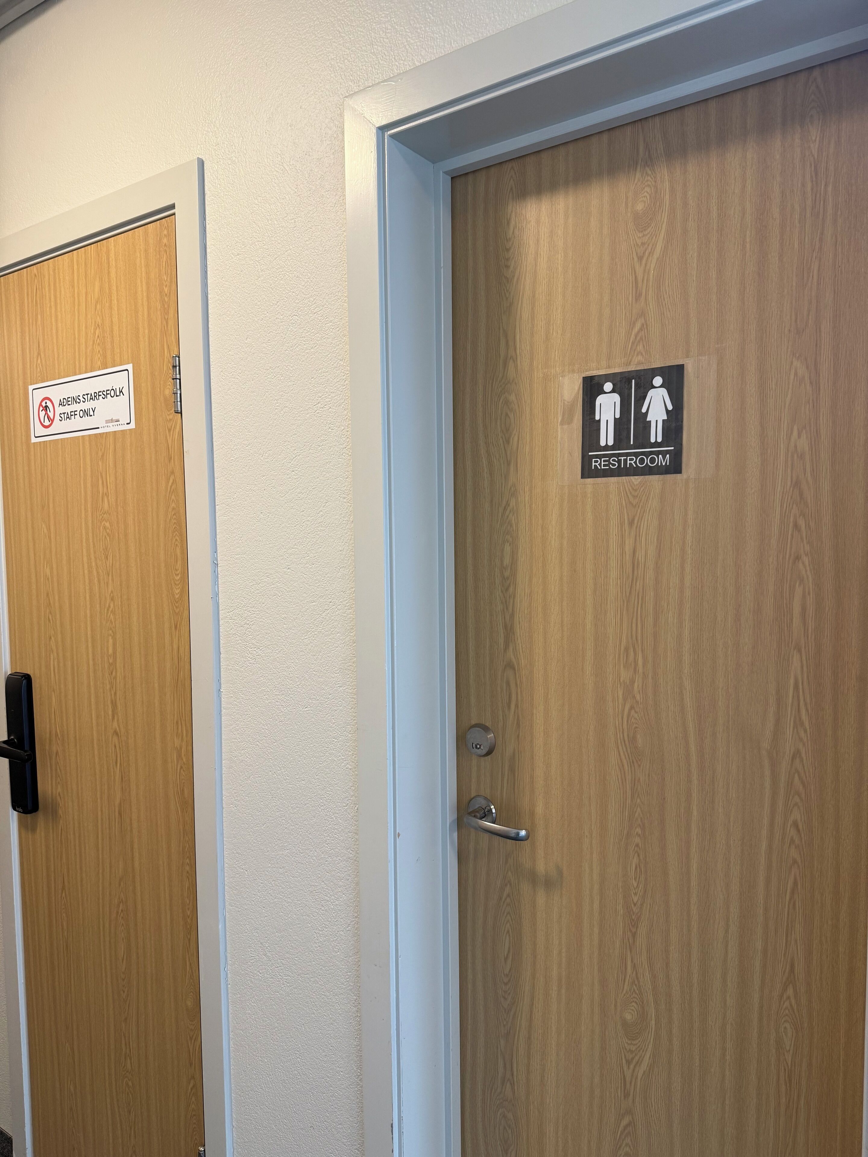 Dos puertas: una con un letrero que dice 'Solo personal' y otra con un letrero que indica 'Baño'.