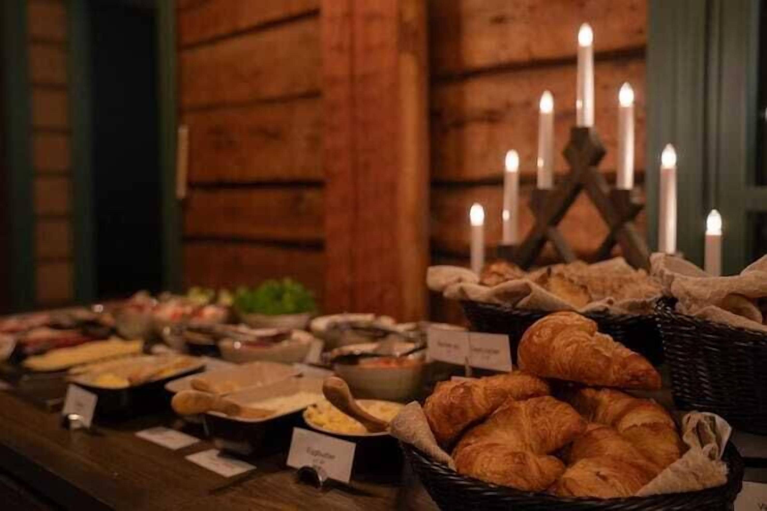 A buffet with various food items and baskets of croissants.