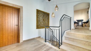Una escalera con una puerta de madera y un panel decorativo en la pared.