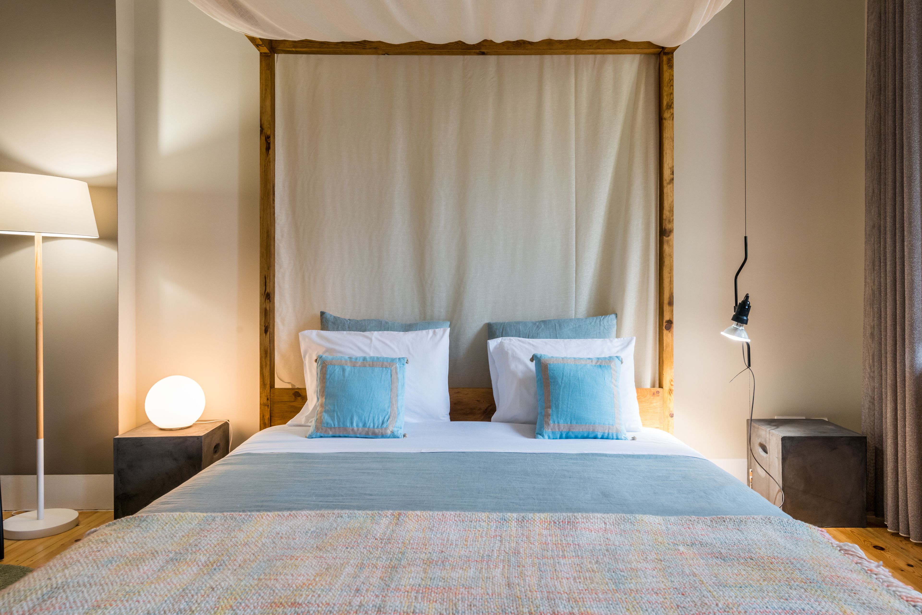 A bedroom with a bed, bedside lamps, and a nightstand.