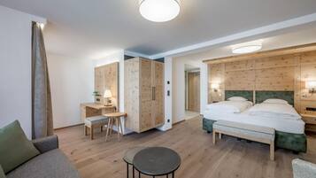 A hotel room with a bed, a desk, a chair, and a small table.