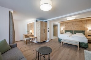 A hotel room with a bed, a desk, a chair, and a small table.