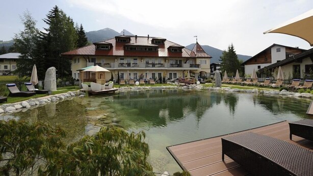 A hotel with a pool, outdoor seating, and mountain views. - Wellnesshotel Schonruh - Adults Only (Seefeld in Tirol)
